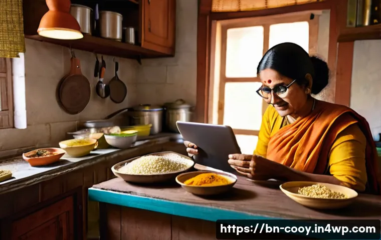 가족 레시피의 디지털 저장법 - A cozy Bengali family kitchen scene featuring a middle-aged woman using a smartphone and laptop side...